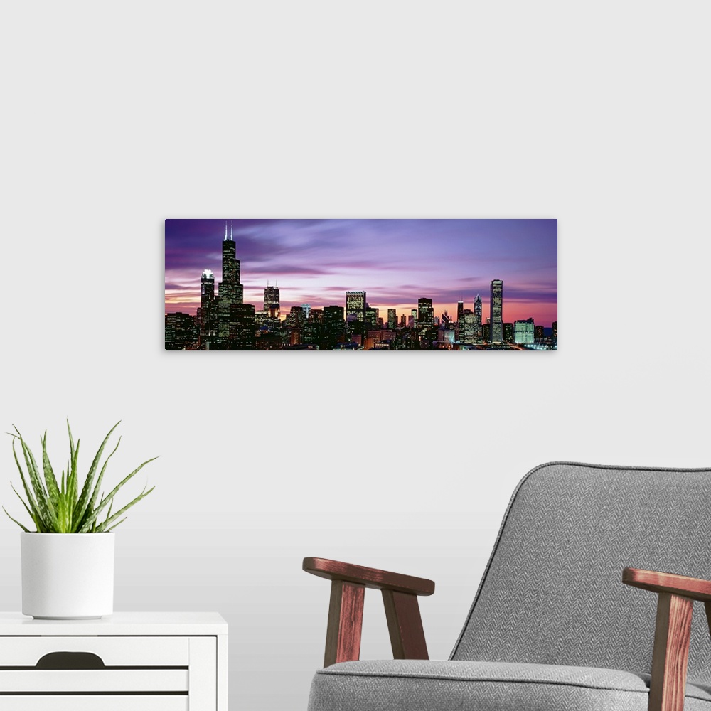 A modern room featuring This is a panoramic photograph of a sunset behind the shining city skyline in the Midwest.