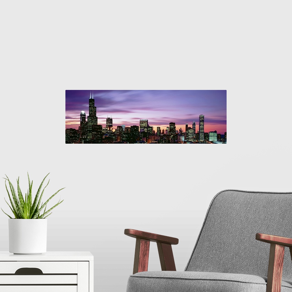 A modern room featuring This is a panoramic photograph of a sunset behind the shining city skyline in the Midwest.