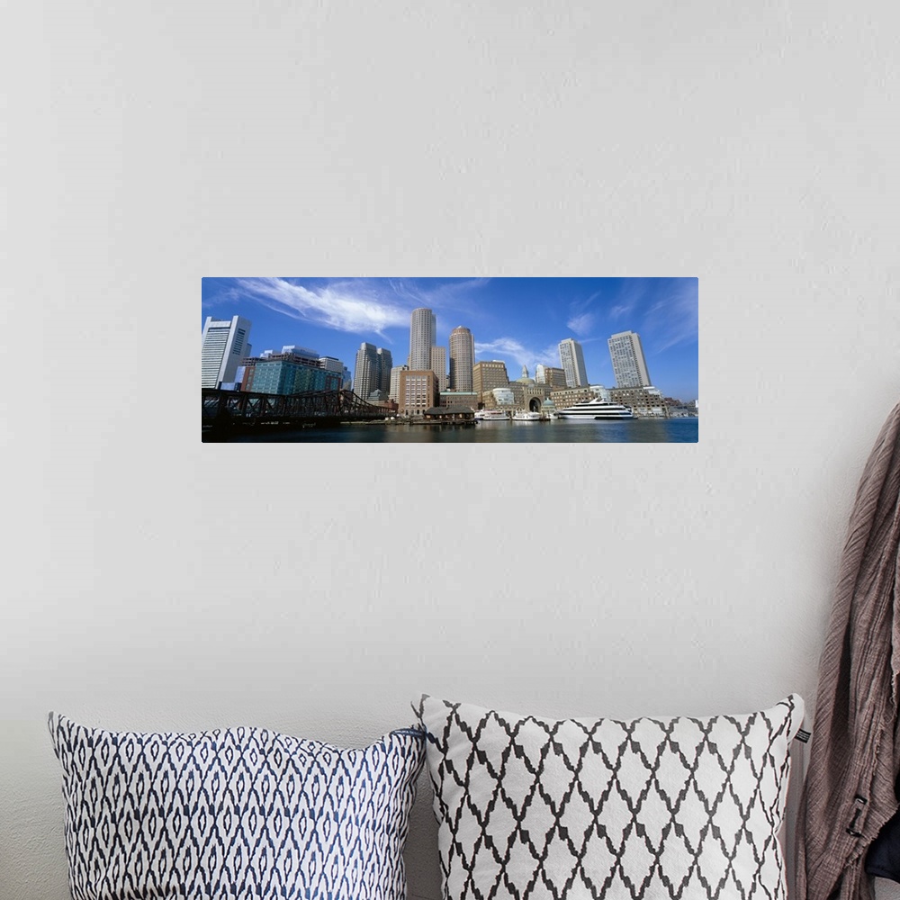 A bohemian room featuring The Boston skyline is photographed in panoramic view from the waterfront during a bright sunny day.