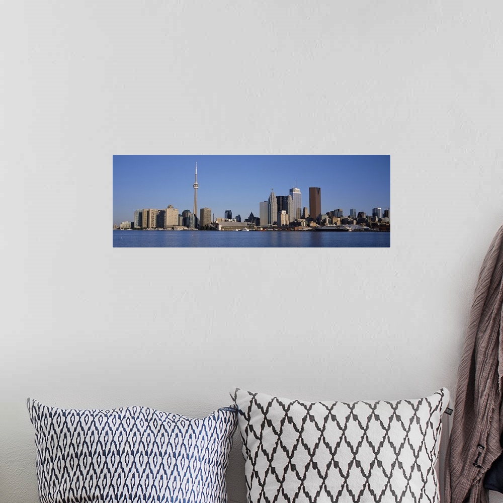 A bohemian room featuring Panorama of a city skyline of tall modern buildings on the edge of a lake on a sunny day with a c...