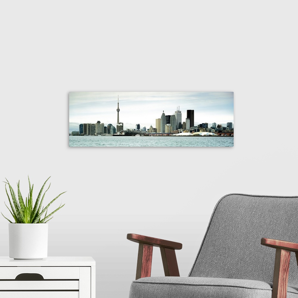 A modern room featuring This decorative accent is a panoramic photograph of the downtown city skyline taken from across t...