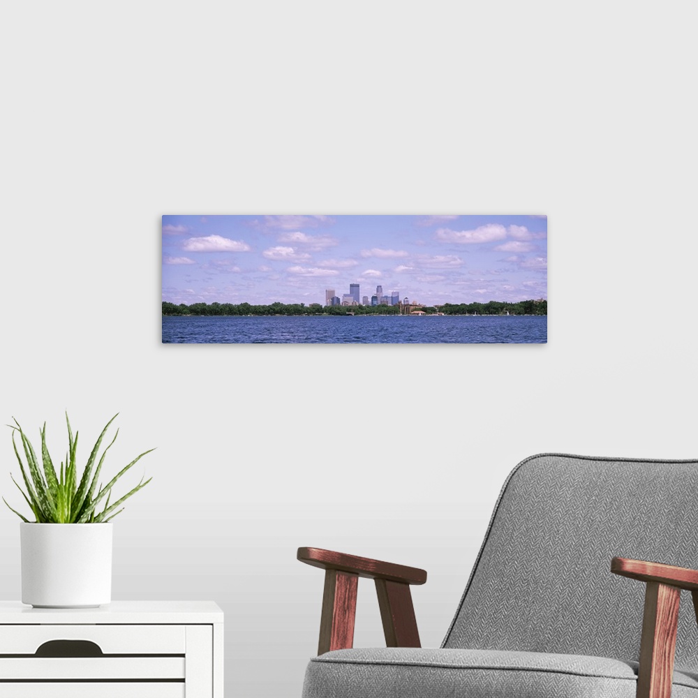 A modern room featuring Panorama depicting Minneapolis downtown with a cloud-filled sky and a view of Chain of Lakes Park...