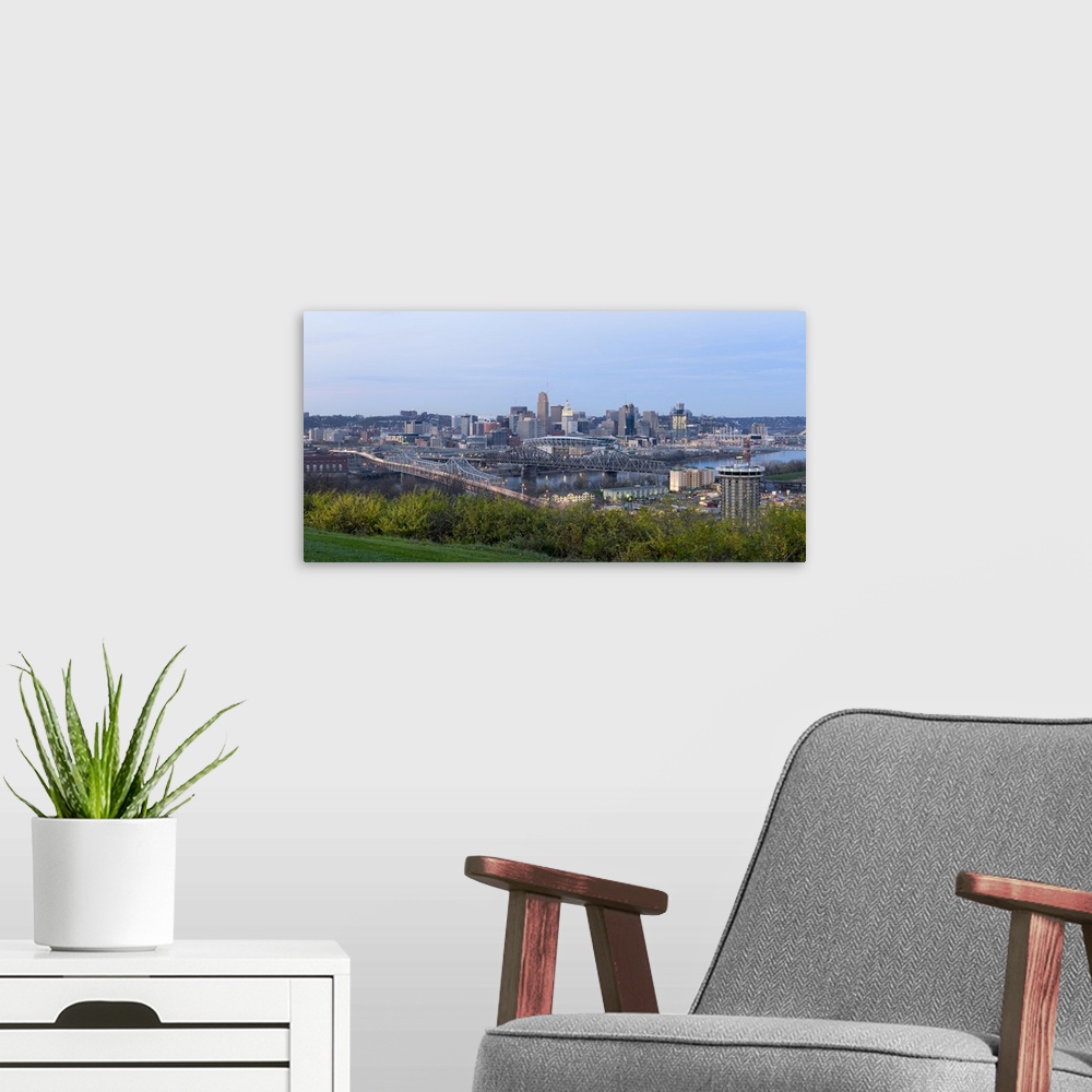 A modern room featuring Horizontal, distant photograph of bridges and skyscrapers of the Cincinnati, Ohio skyline, grass ...