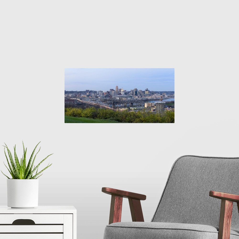 A modern room featuring Horizontal, distant photograph of bridges and skyscrapers of the Cincinnati, Ohio skyline, grass ...