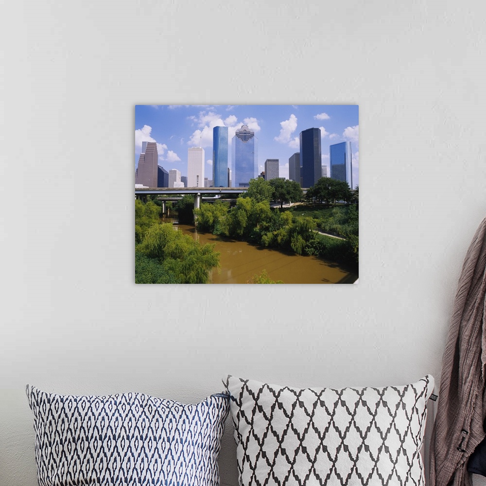 A bohemian room featuring This is a nearly square landscape photograph of cityos downtown skyscrapers and a river that pass...