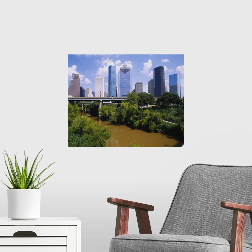 A modern room featuring This is a nearly square landscape photograph of cityos downtown skyscrapers and a river that pass...