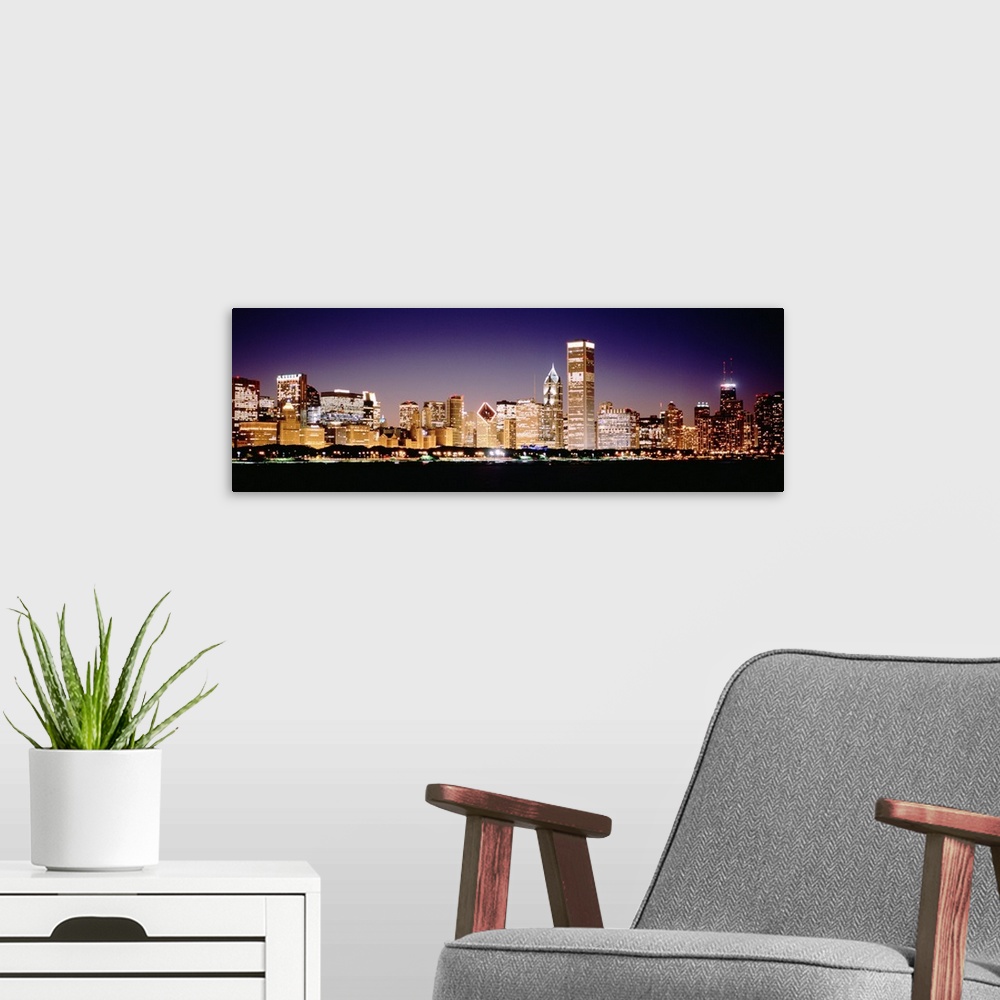 A modern room featuring Panoramic photograph shows the intensely vibrant lights of skyscrapers that fill the busy skyline...
