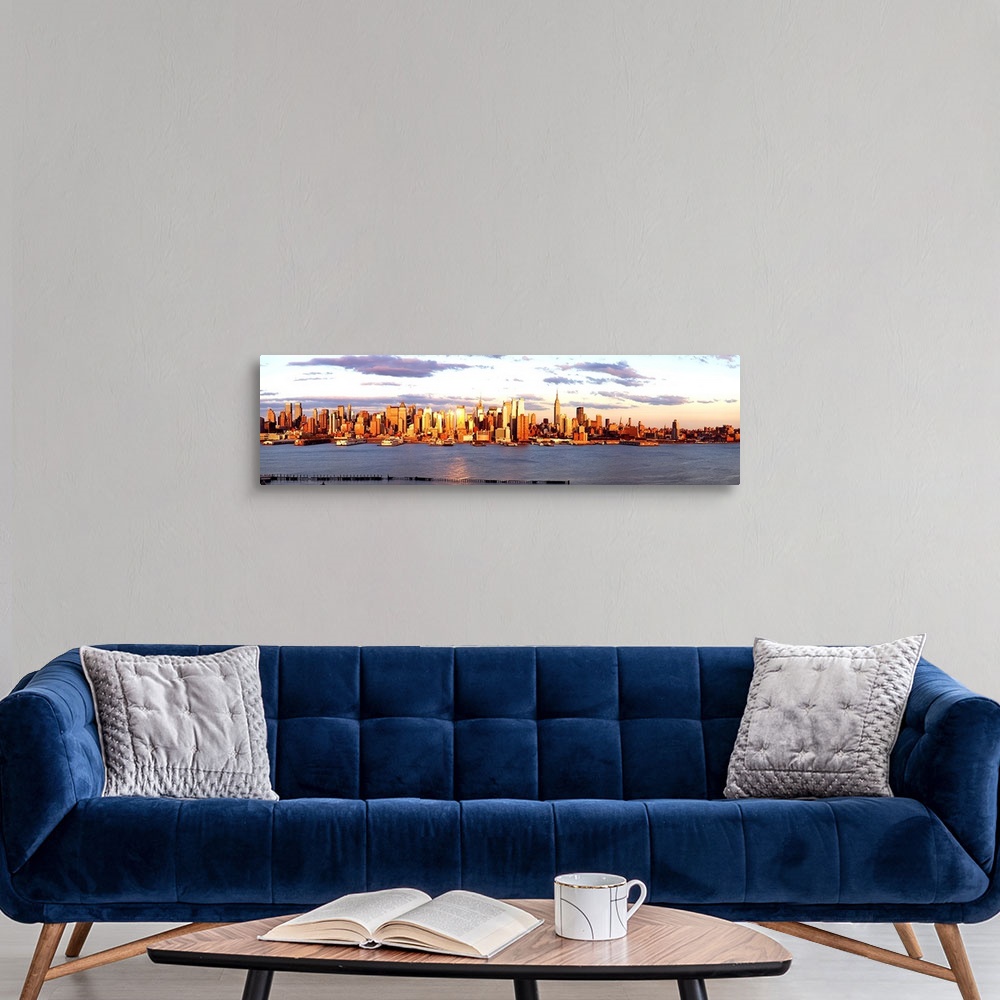 A modern room featuring Panoramic photograph of the distant Manhattan skyline at the waters edge, with golden skyscrapers...