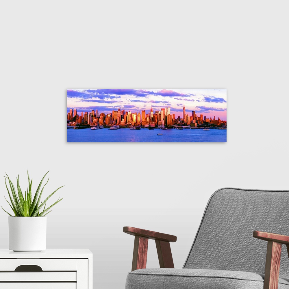 A modern room featuring Panoramic photograph of the water in front of the New York City skyline, beneath a vibrant, partl...