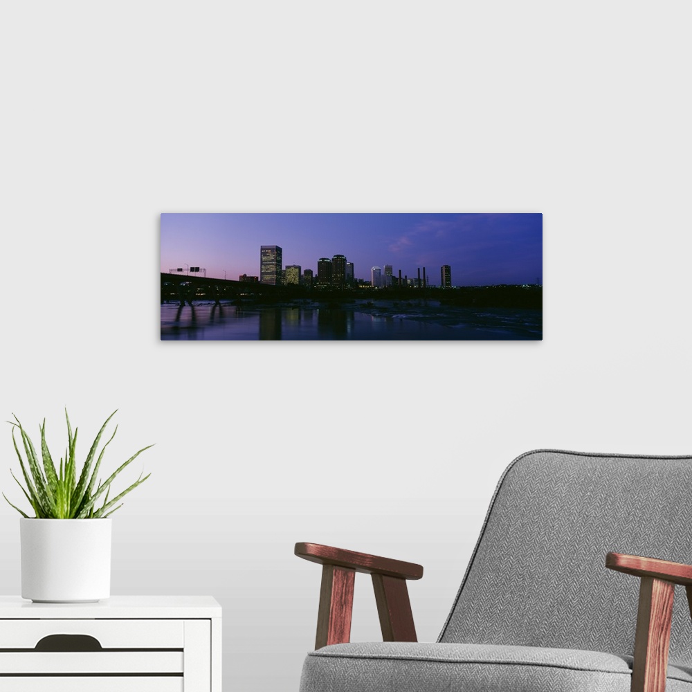 A modern room featuring This decorative wall art for the home or office is a panoramic photograph of the city downtown ta...