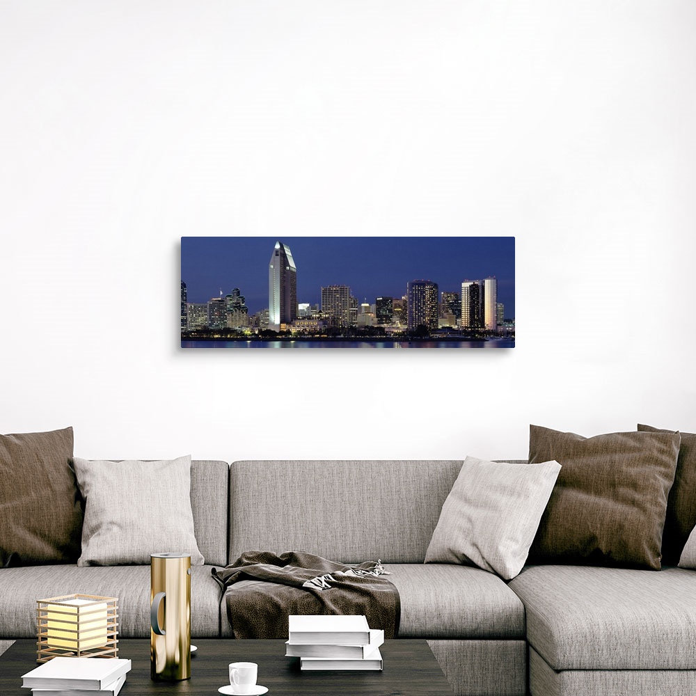 A traditional room featuring This large panoramic photograph is of the San Diego skyline at night with all of the buildings li...