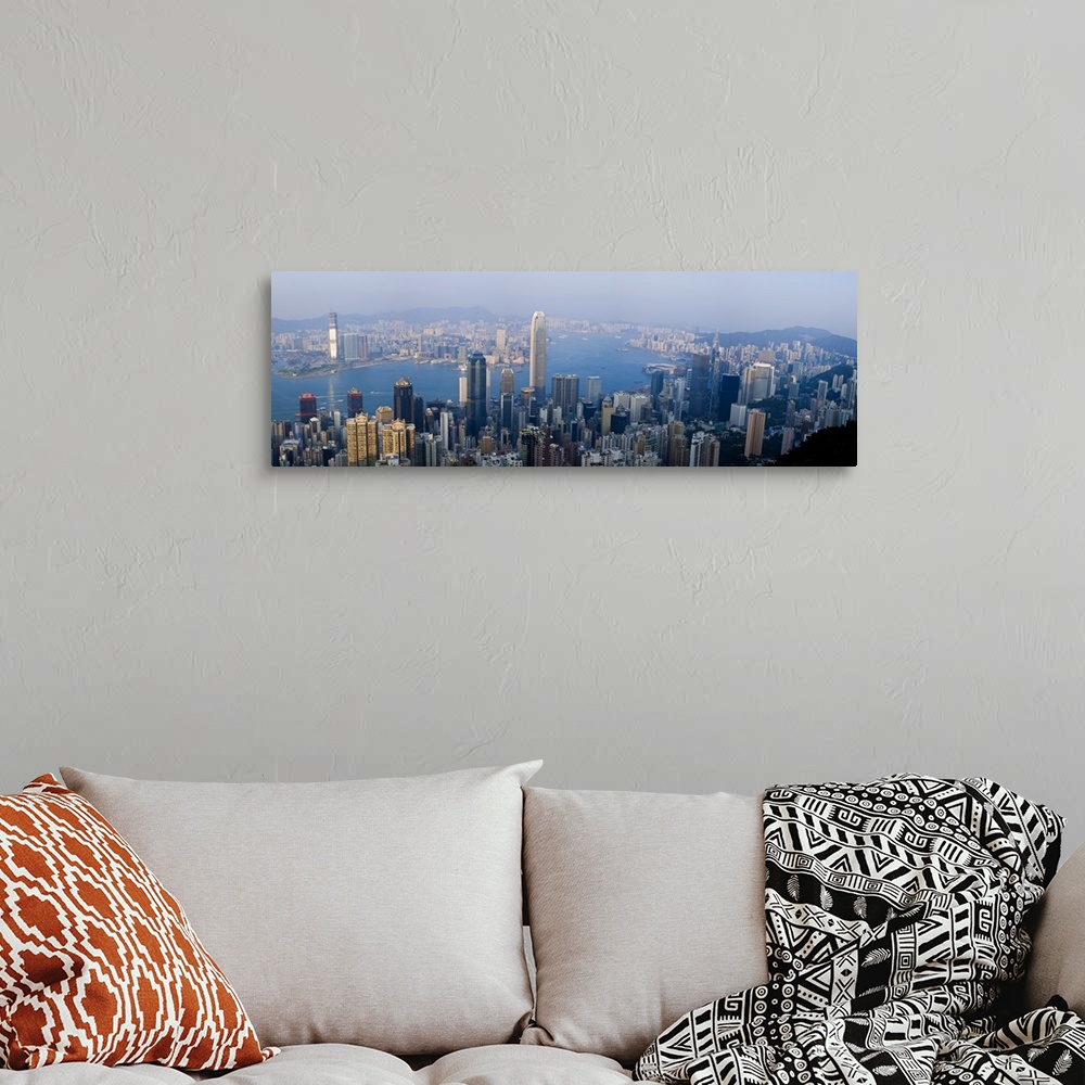 A bohemian room featuring Wide angel, aerial photograph of large buildings in Hong Kong, China, surrounding Victoria Harbour.