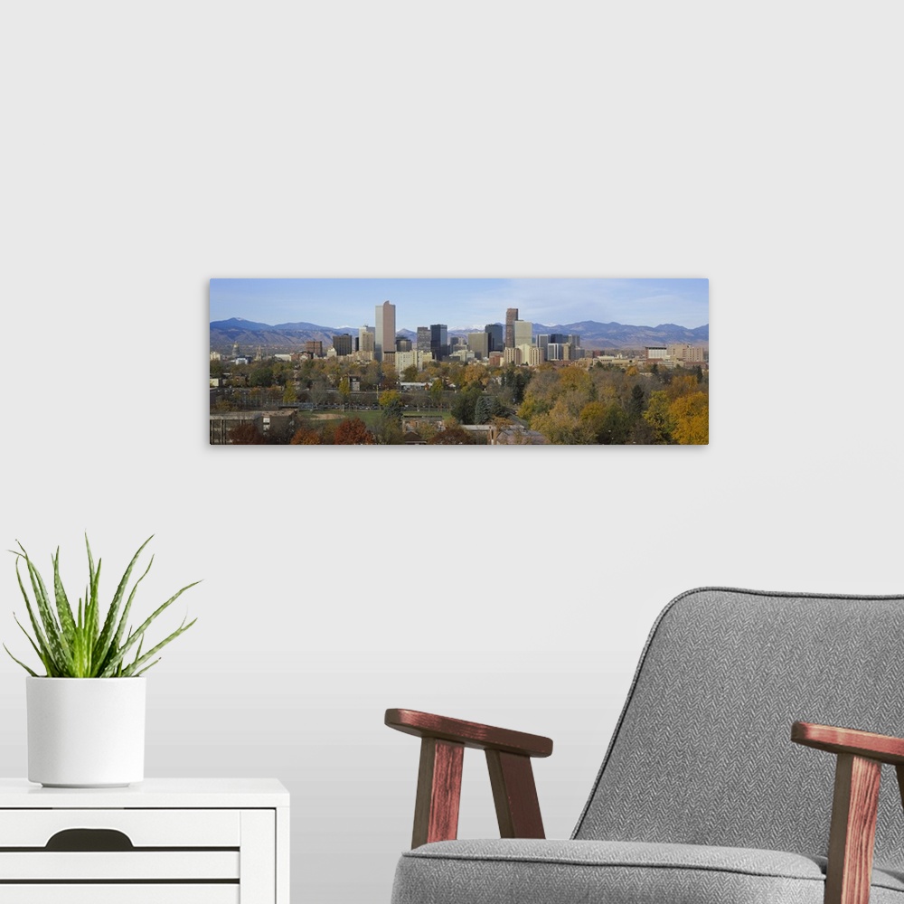 A modern room featuring An urban city skyline nestled in a Rocky Mountain valley with a baseball field and several trees ...