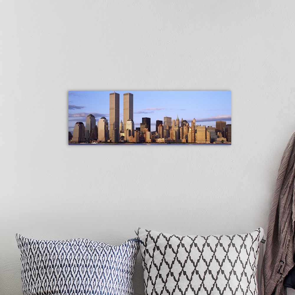 A bohemian room featuring The Manhattan skyline is photographed in panoramic view with the World Trade Center buildings sta...
