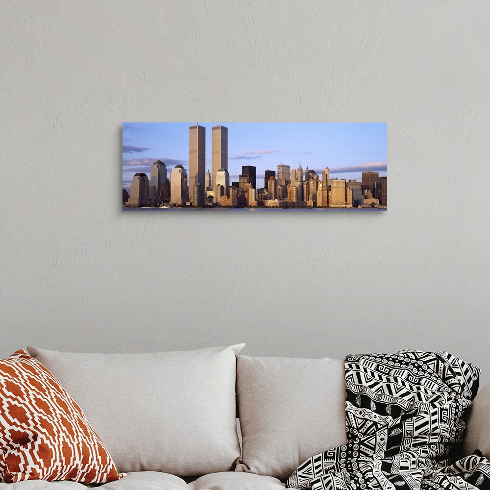A bohemian room featuring The Manhattan skyline is photographed in panoramic view with the World Trade Center buildings sta...