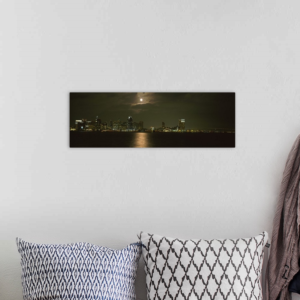 A bohemian room featuring Panoramic photograph taken at nighttime shows a distant view of the brightly lit skyline within a...