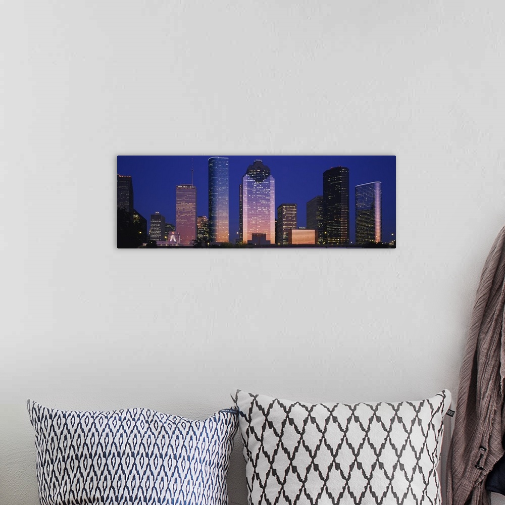 A bohemian room featuring Large panoramic view of the Houston skyline with the buildings illuminated during the night.