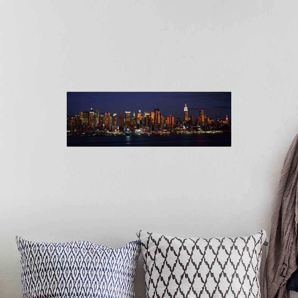 A bohemian room featuring Panoramic photograph of skyscrapers filling the skyline of Manhattan in New York at night.  The b...