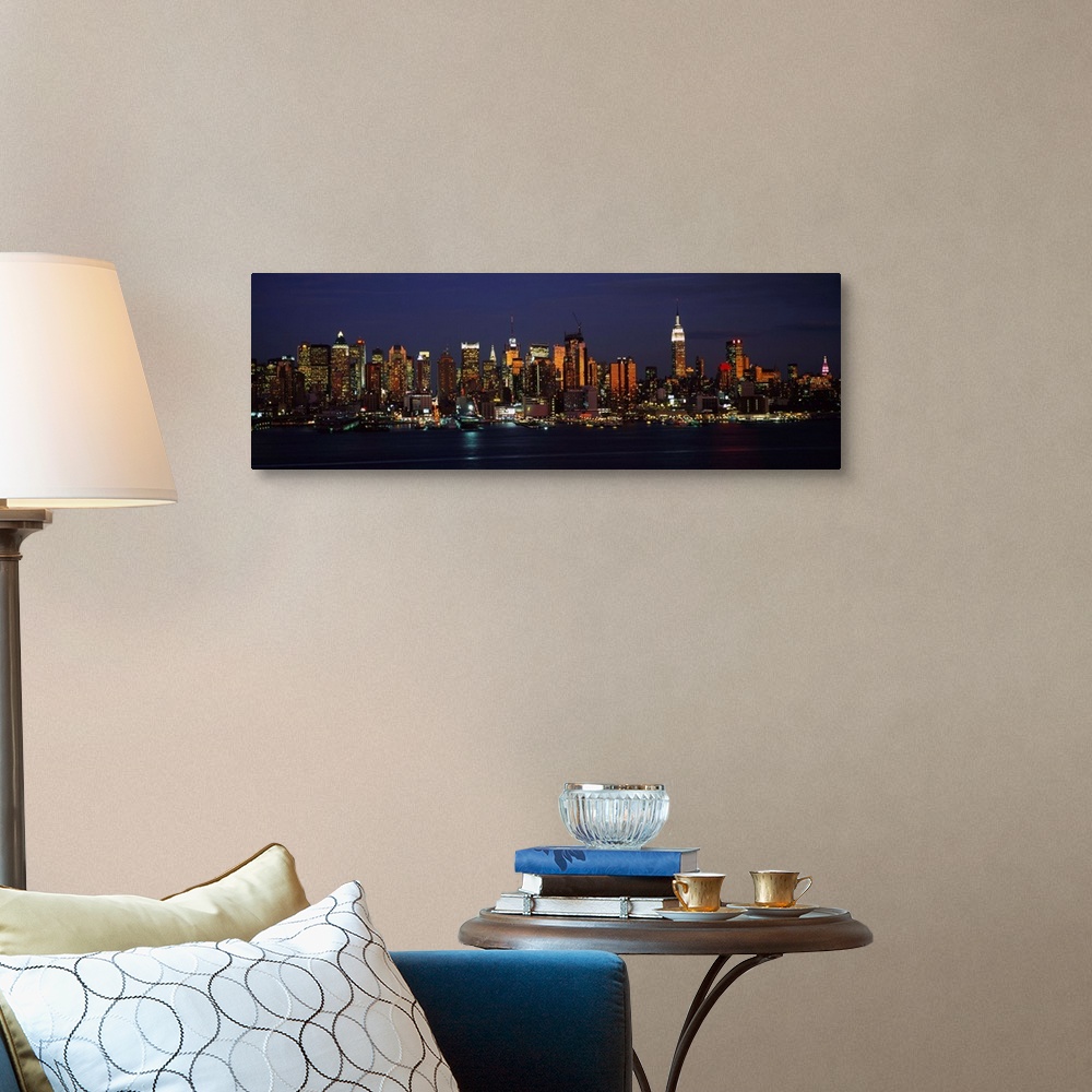 A traditional room featuring Panoramic photograph of skyscrapers filling the skyline of Manhattan in New York at night.  The b...
