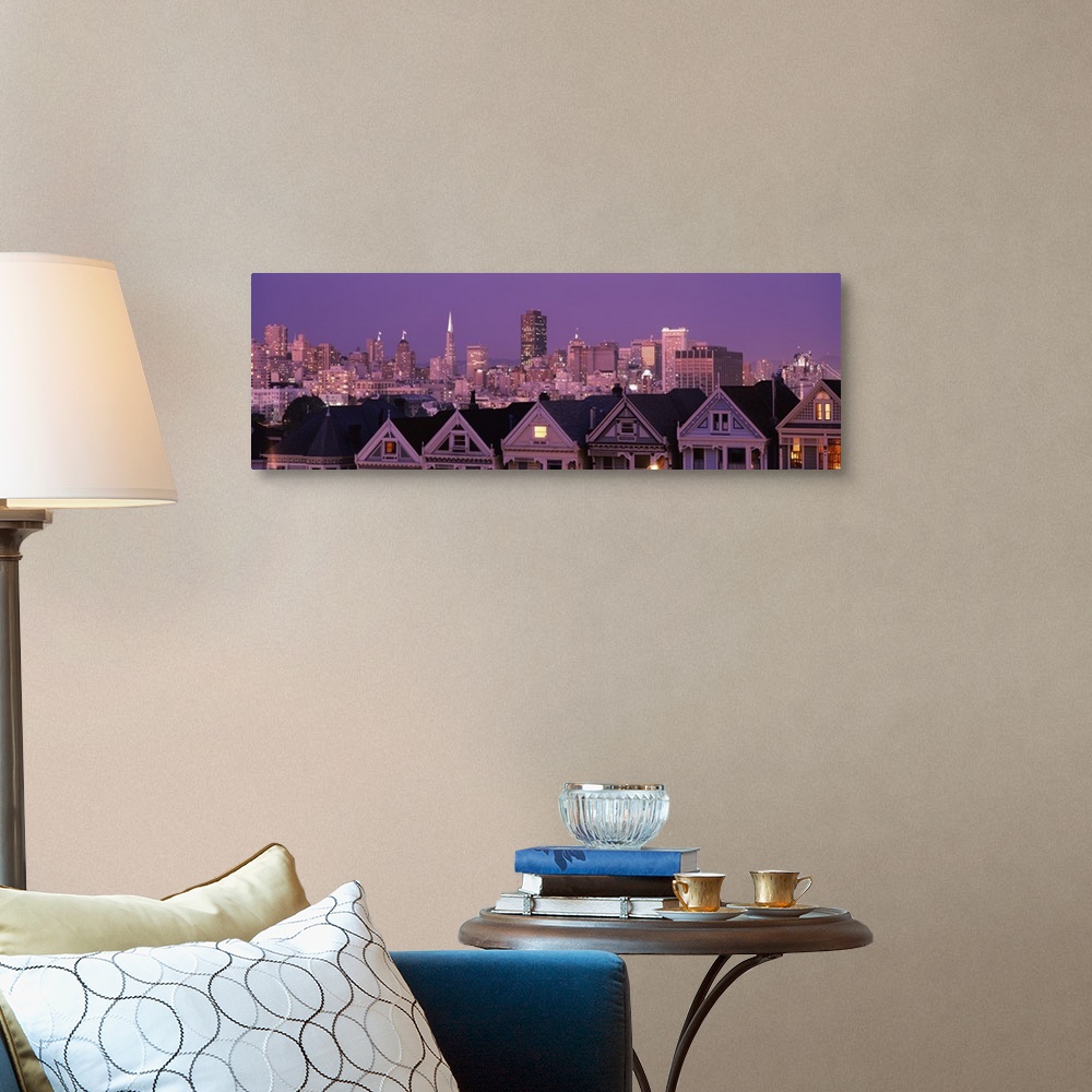 A traditional room featuring The San Francisco skyline is illuminated at night and photographed in wide angle view from a dist...