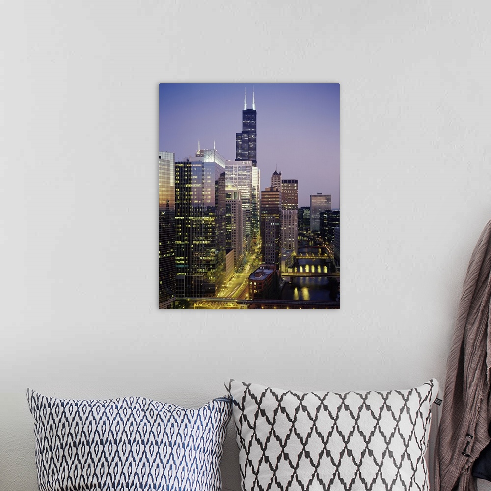A bohemian room featuring Vertical photograph of several towering buildings in the urban city of Chicago at twilight.