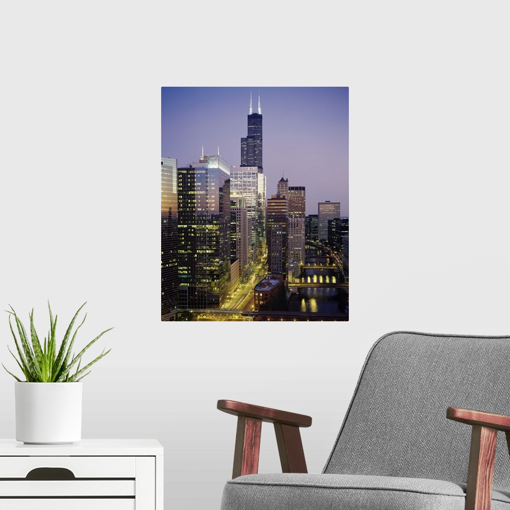 A modern room featuring Vertical photograph of several towering buildings in the urban city of Chicago at twilight.