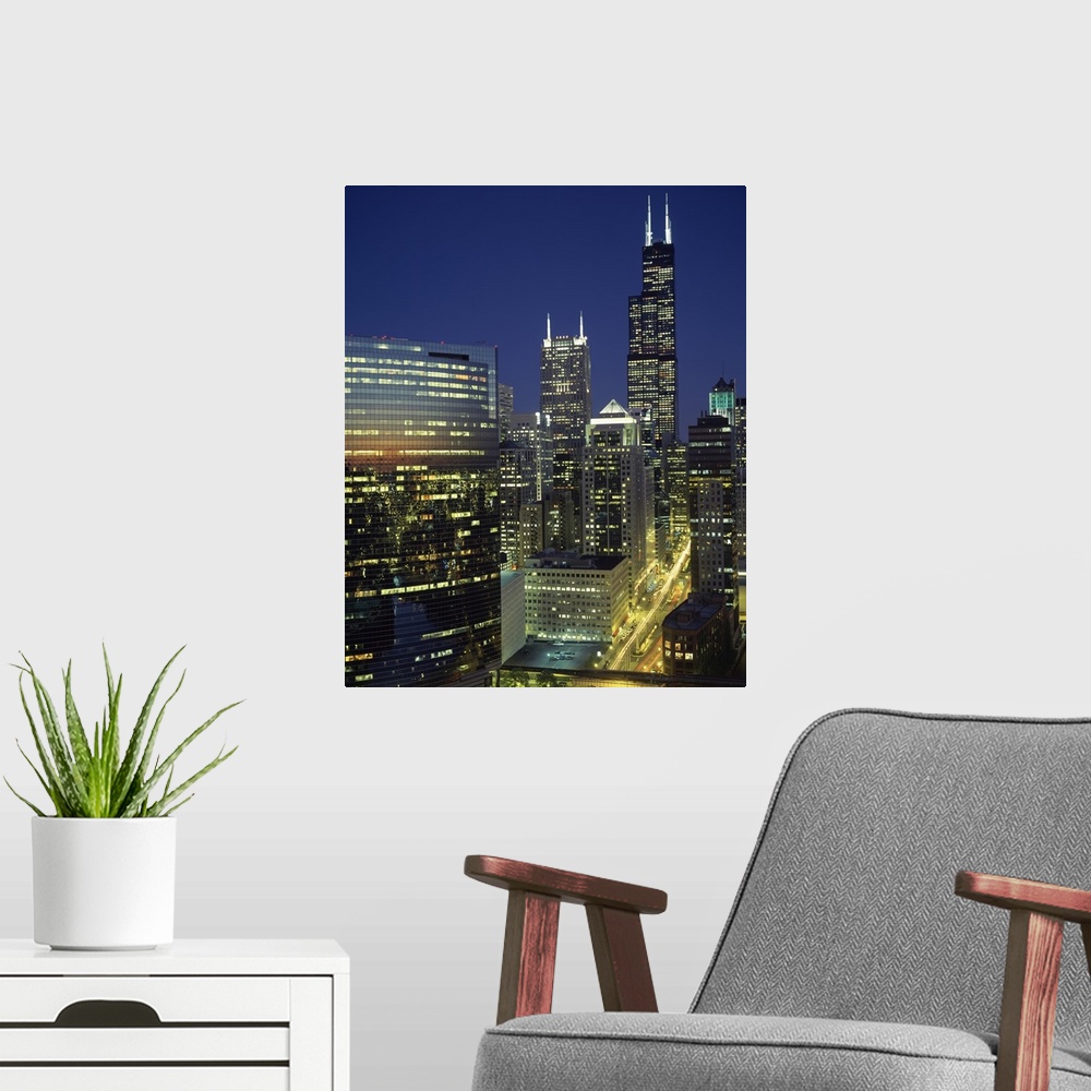 A modern room featuring Vertical, high angle photograph overlooking Wacker Drive in Chicago, surrounded by lit buildings ...