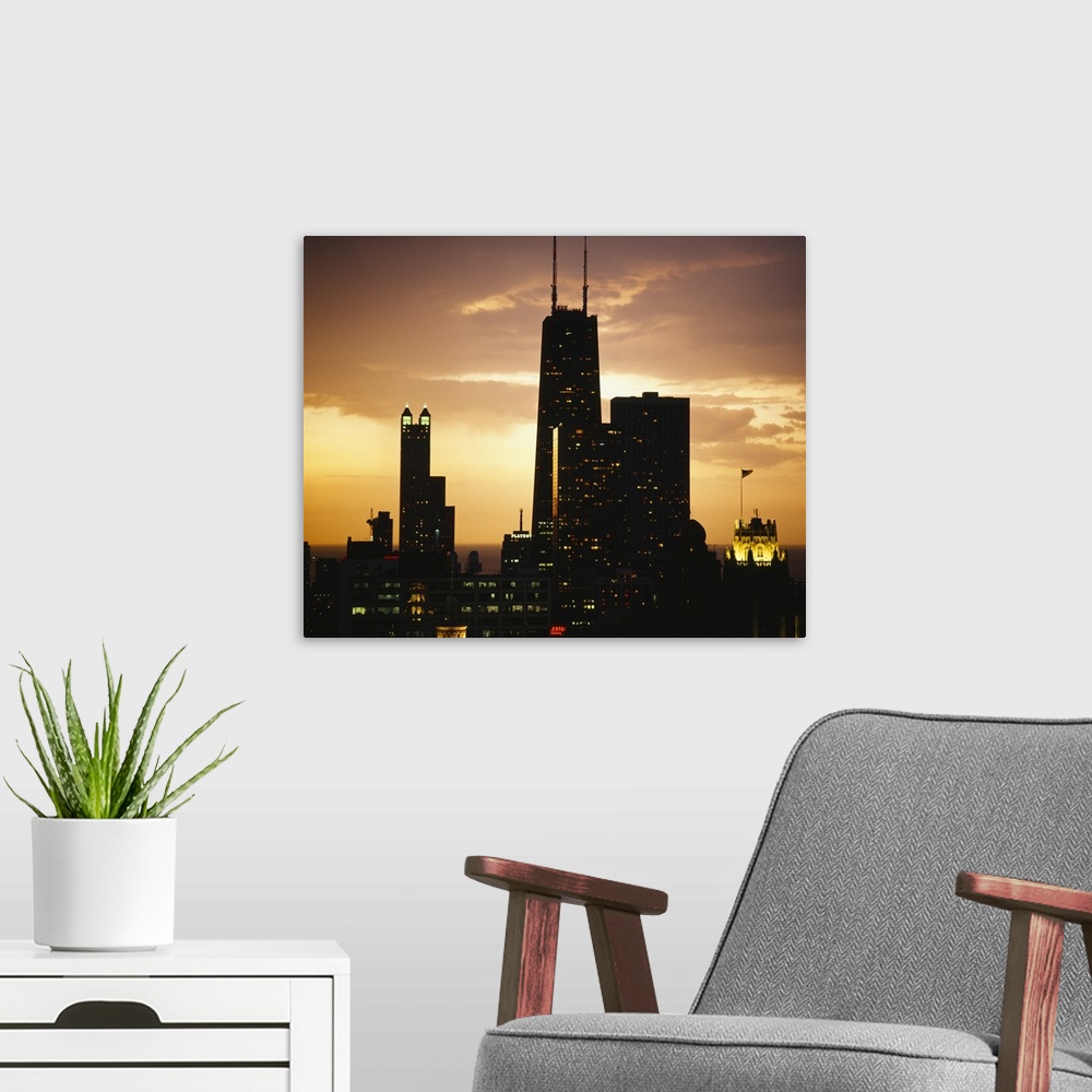 A modern room featuring Horizontal photograph on a big canvas of lit, tall buildings  of the Chicago skyline against the ...