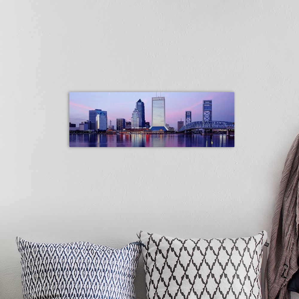 A bohemian room featuring A panorama view of the city skyline in Jacksonville during dusk. The buildings lights reflect in ...