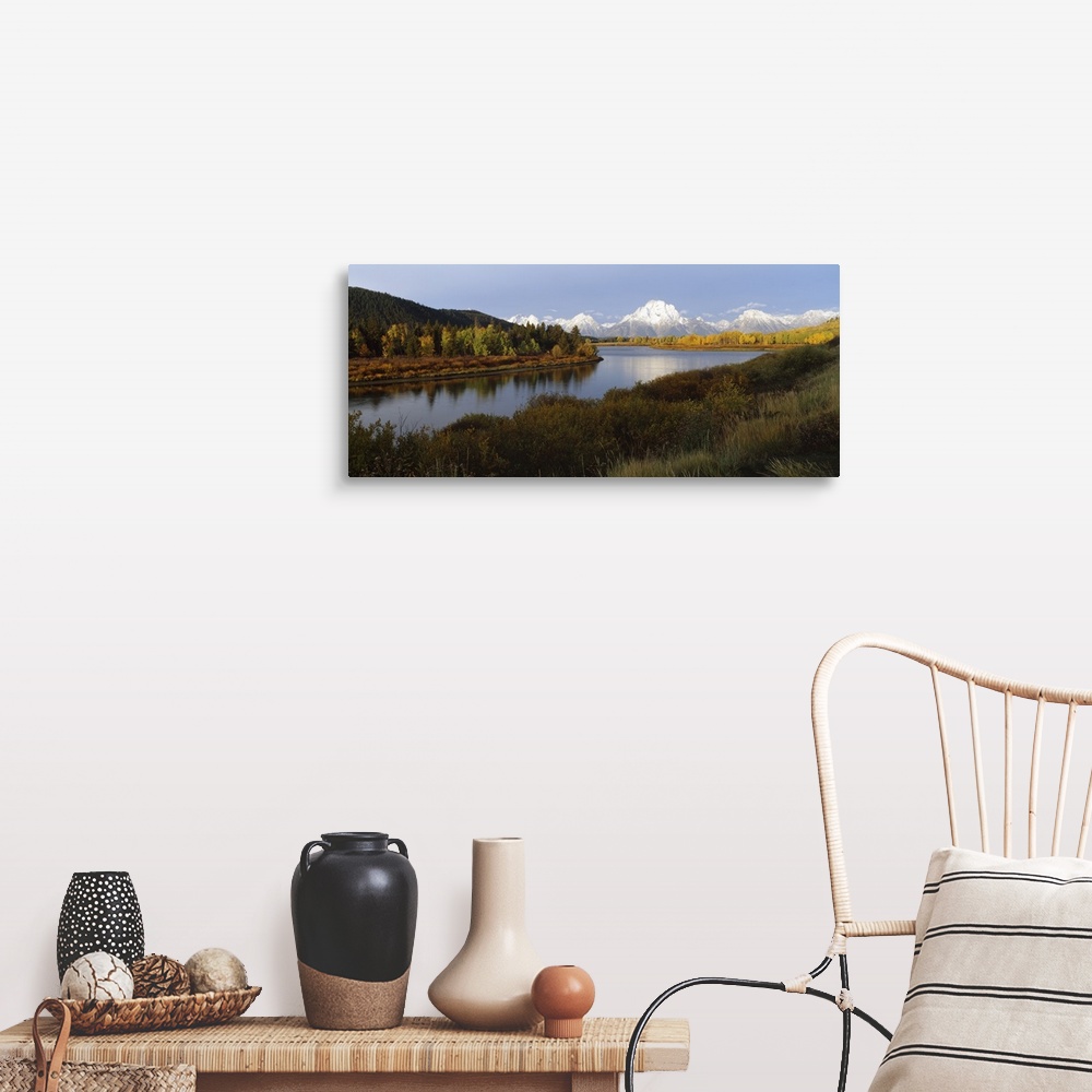 A farmhouse room featuring A landscape photograph of a river winding through the meadowlands with snow covered mountain peak...