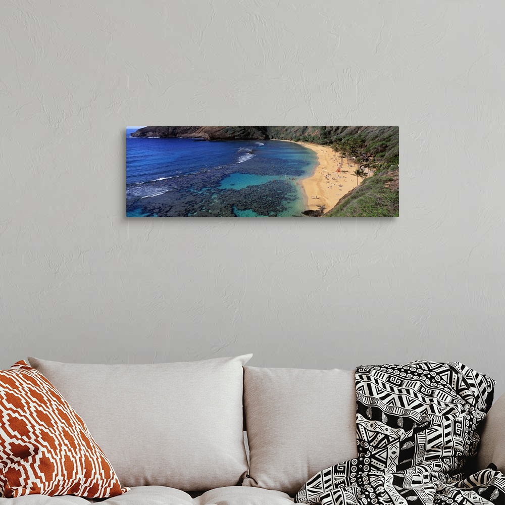 A bohemian room featuring Panoramic photograph of inlet with coral and beach lined with mountains.