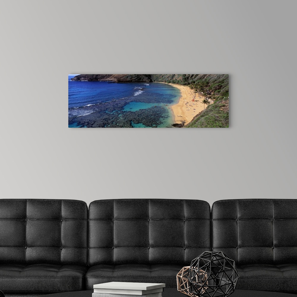 A modern room featuring Panoramic photograph of inlet with coral and beach lined with mountains.