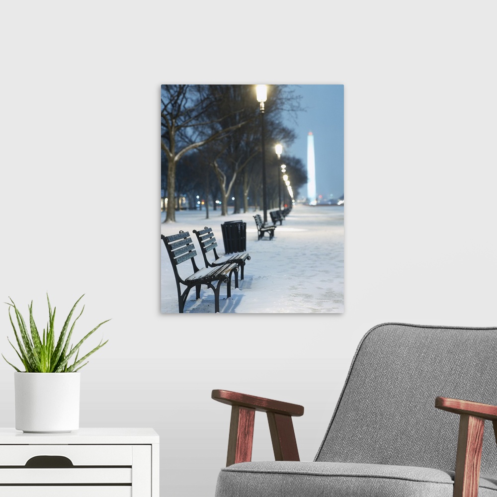 A modern room featuring Snow covers the National Mall and rows of out of focus benches and street lights in this vertical...