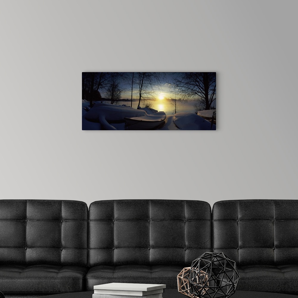 A modern room featuring Panoramic photograph displays a group of rowboats blanketed in fresh powder sitting near the shor...