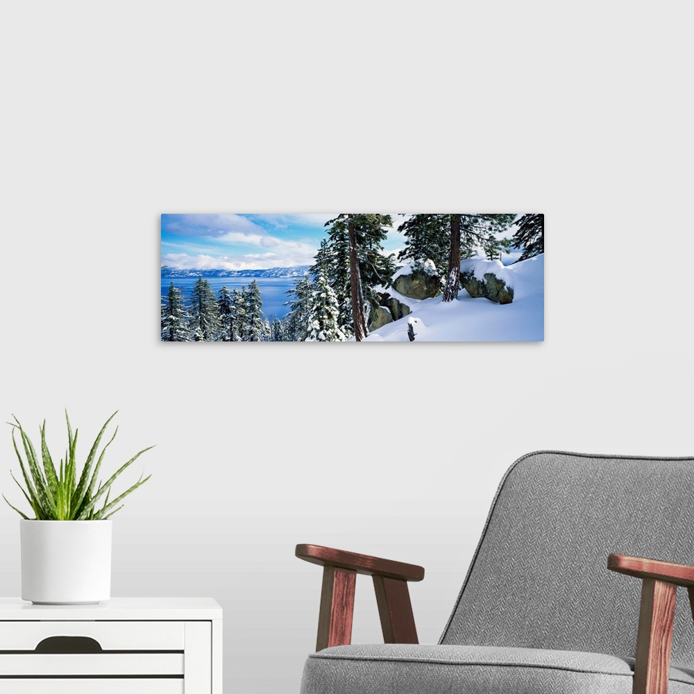 A modern room featuring A landscape photograph taken from a mountain ridge in winter looking down into the scenic lake an...
