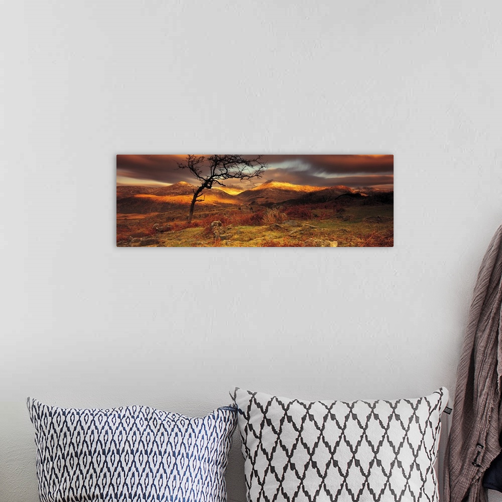 A bohemian room featuring Vast hills and bare land are photographed in panoramic view. Sun touches part of the hills and a ...