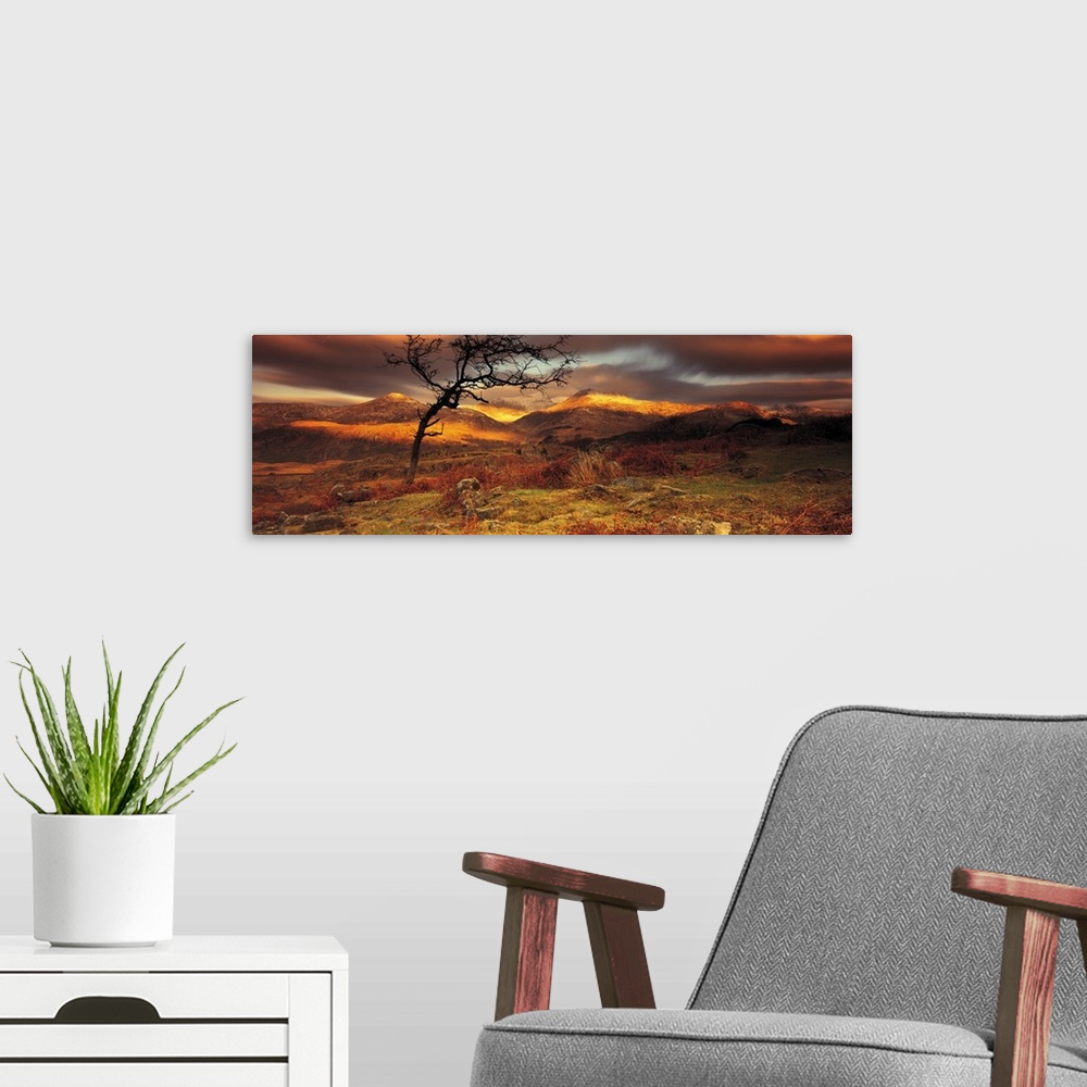 A modern room featuring Vast hills and bare land are photographed in panoramic view. Sun touches part of the hills and a ...