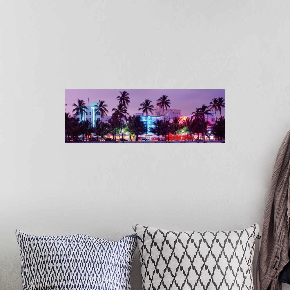A bohemian room featuring View from the shore of Ocean Driveos art deco neon signs and palm trees.