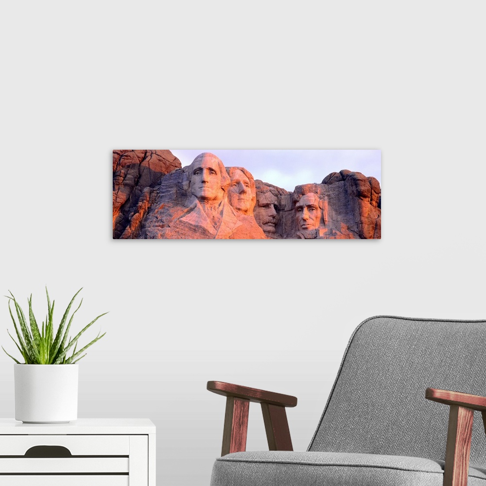 A modern room featuring Panorama of the world famous monument, Mount Rushmore, cast in the light of the setting sun.