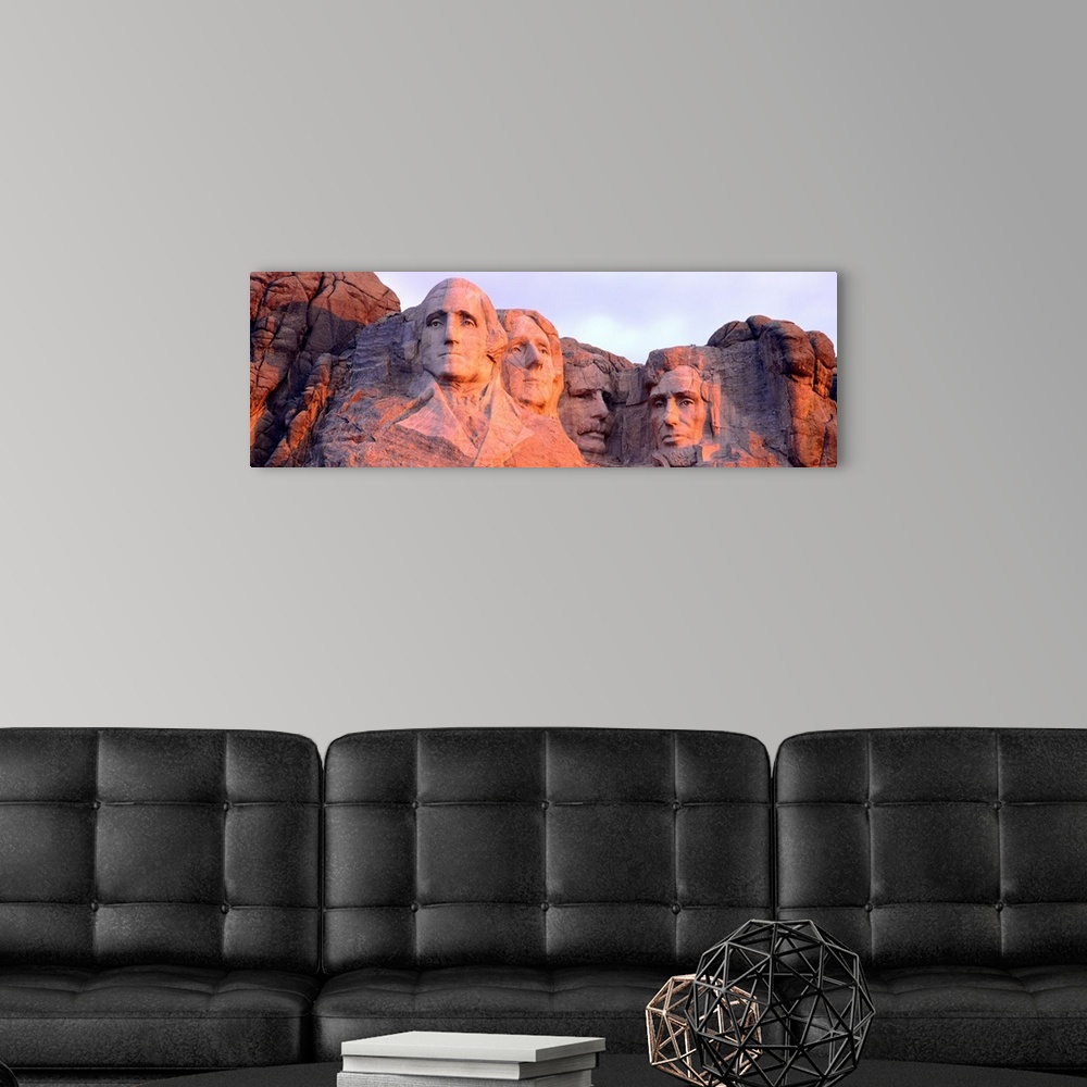 A modern room featuring Panorama of the world famous monument, Mount Rushmore, cast in the light of the setting sun.