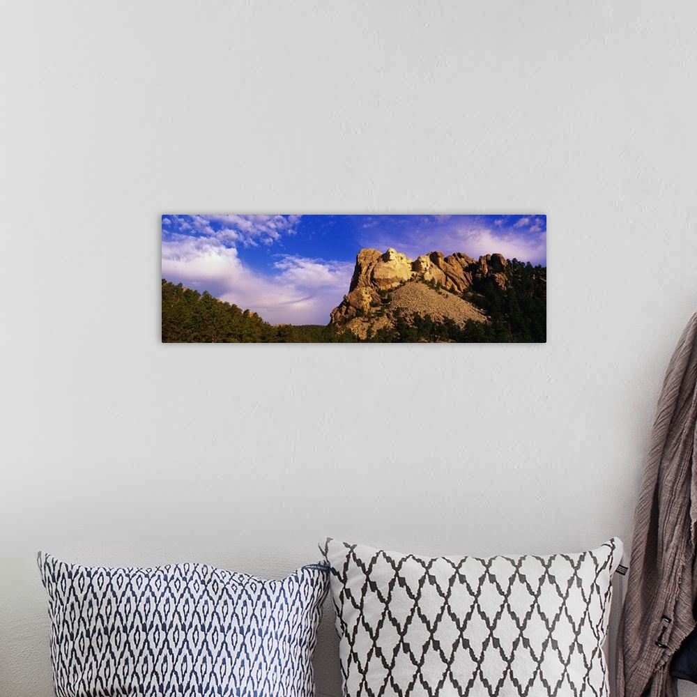 A bohemian room featuring A picture of Mount Rushmore is taken from a distance and has it skewed to the right in this panor...