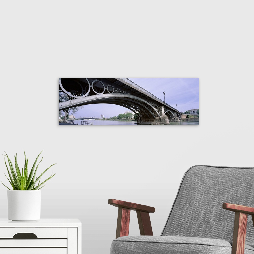 A modern room featuring Spain, Seville, Low angle view of Isabel II Bridge over Guadalquivir River