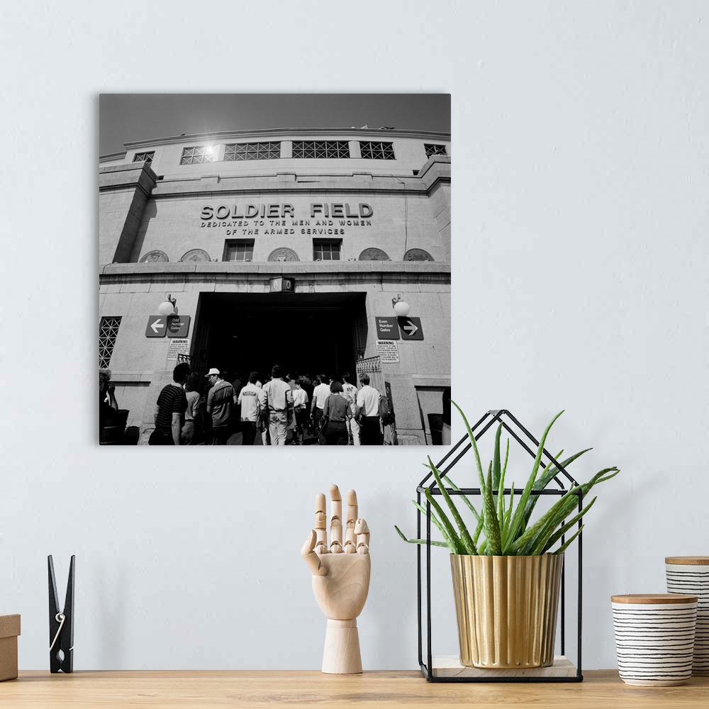 A bohemian room featuring A black and white photograph of fans entering the Chicago Bears stadium with the fields name disp...
