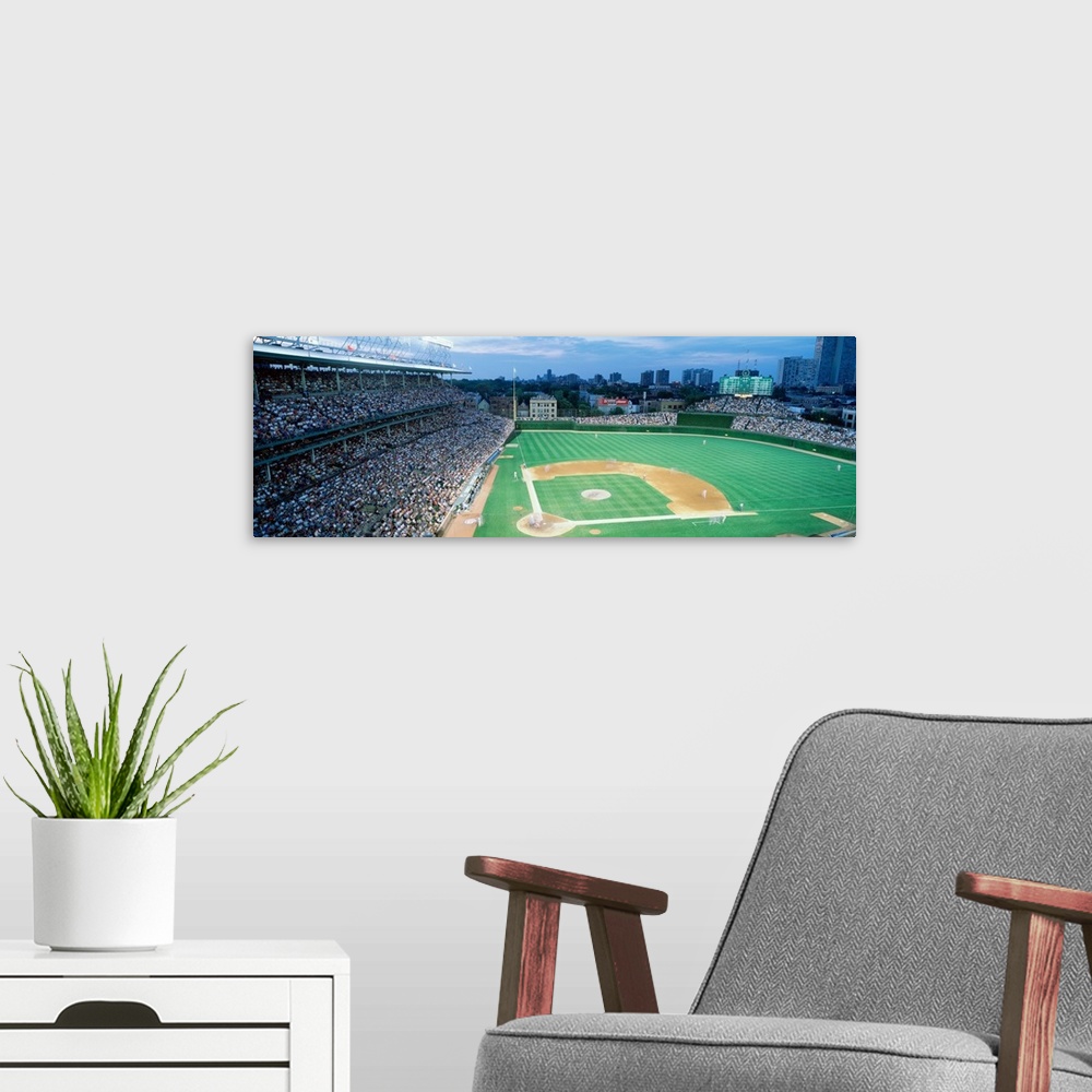 A modern room featuring Panoramic shot of Wrigley Field and the baseball diamond during a game as the crowd cheers.