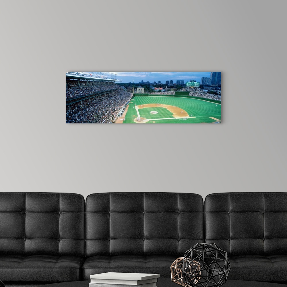 A modern room featuring Panoramic shot of Wrigley Field and the baseball diamond during a game as the crowd cheers.
