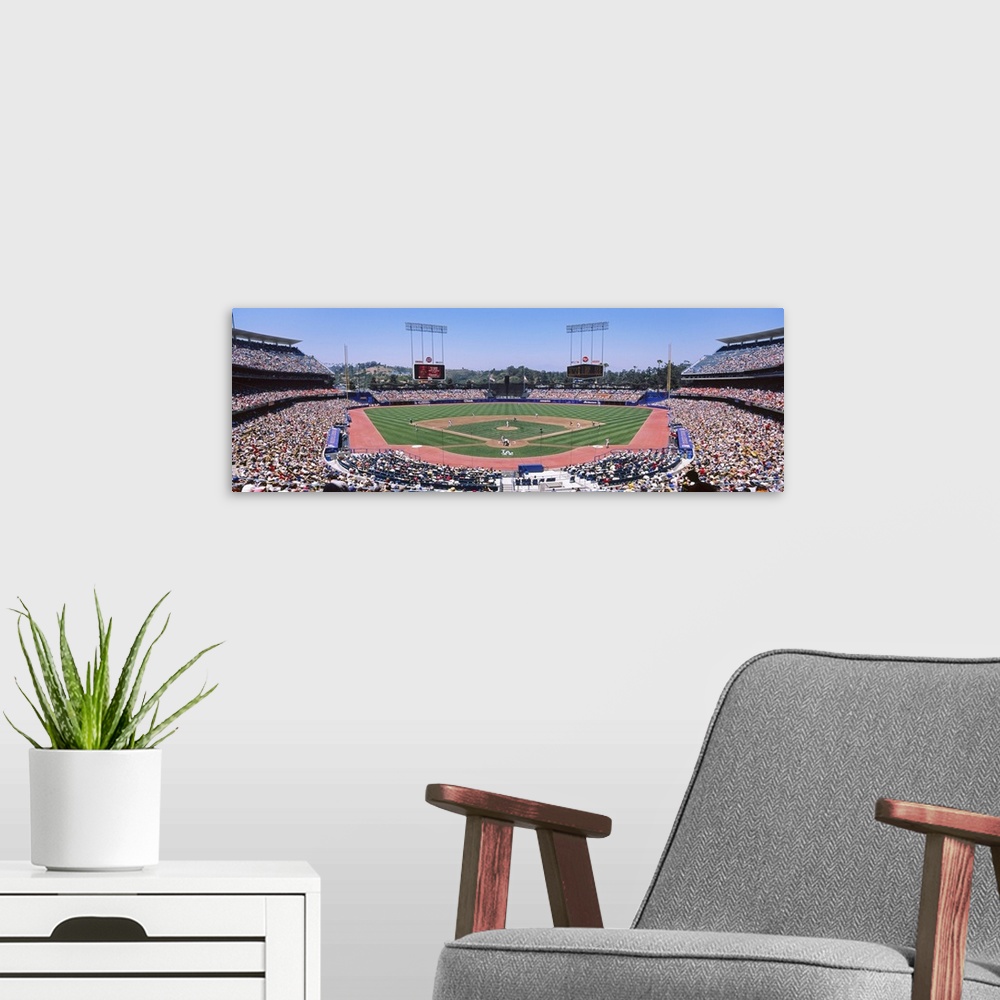 A modern room featuring Panoramic photograph of inside baseball stadium with game in full swing.  The stands are packed w...