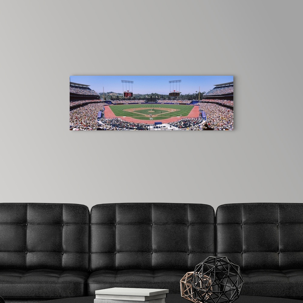 A modern room featuring Panoramic photograph of inside baseball stadium with game in full swing.  The stands are packed w...