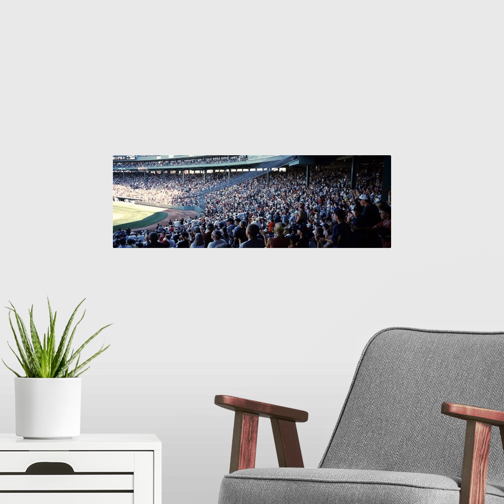 A modern room featuring Panoramic, big photograph of packed stands of fans watching a baseball game at Fenway Park, in Bo...
