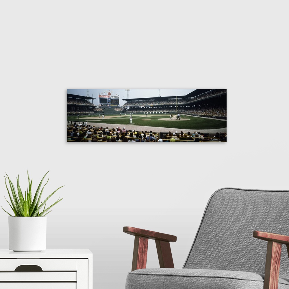 A modern room featuring Panoramic image of people watching a baseball game seen at field level.