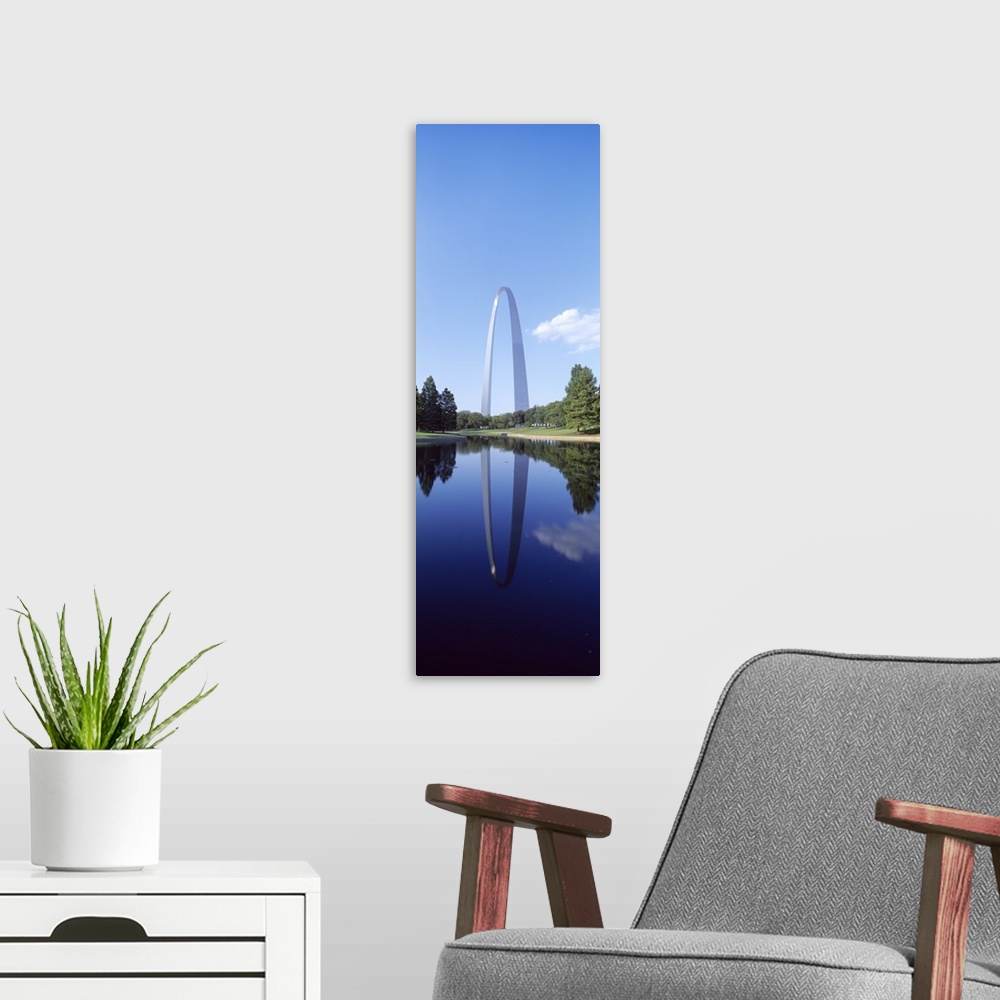 A modern room featuring A tall panoramic piece of the famous gateway arch that is photographed from the side over a body ...